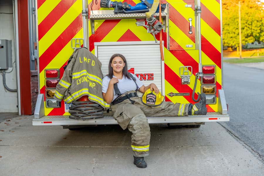 High school senior sitting on the back of a fire truck for Wildcard photo shoot