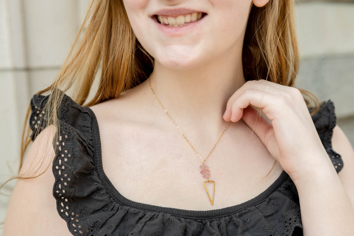 close up of necklace on a young woman smiling